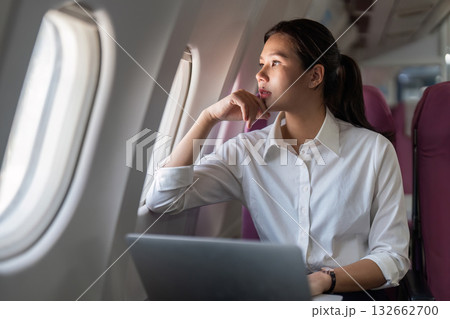 Business travel woman working on laptop while flying on an airplane 132662700