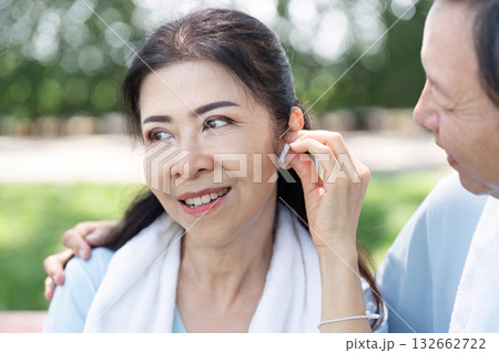 Wellness and Senior Technology. A senior couple enjoying music together while exercising outdoors. Wellness and Senior Technology. A senior couple enjoying music together while exercising outdoors. 132662722