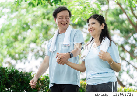 Wellness and Senior Connection. A senior couple walking hand-in-hand, enjoying their time together in a park. 132662725