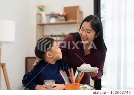Back to School and Family Bonding. A mother shares a treat with her son, celebrating their time together. Back to School and Family Bonding. A mother shares a treat with her son, celebrating their time together. 132662749