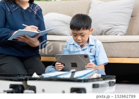 Travel Planning and Preparation. A mother and son discuss their upcoming trip while packing. Travel Planning and Preparation. A mother and son discuss their upcoming trip while packing. 132662789