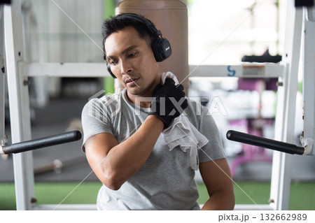 Post-Workout Recovery. Man stretching shoulder after exercise in gym. Post-Workout Recovery. Man stretching shoulder after exercise in gym. 132662989