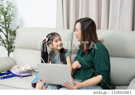 Back to School and Learning Together. A mother and daughter sharing a moment while working on a laptop, preparing for the new school year. 132663061