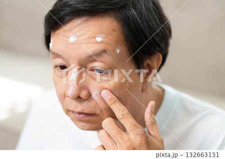 Skincare Routine and Moisturizing. A man applying targeted skincare products to specific areas of his face. 132663131