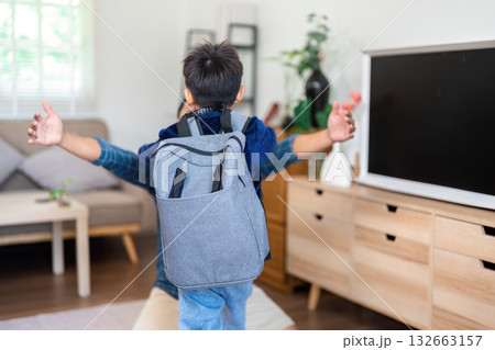 Back to School and Family Reunion. A young boy with a backpack embraces a family member in a warm welcome home. Back to School and Family Reunion. A young boy with a backpack embraces a family member in a warm welcome home. 132663157