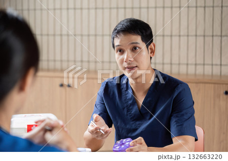 Team Doctor and Meeting. A healthcare professional explains treatment options during a team meeting. Team Doctor and Meeting. A healthcare professional explains treatment options during a team meeting. 132663220