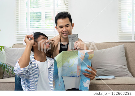 Exciting Travel Preparations. A couple joyfully planning their trip with a map and passport. 132663252