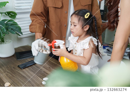 Child and Sustainability. A young girl engaged in eco-friendly gardening activities, enthusiastically spraying a plant while learning about nature. Child and Sustainability. A young girl engaged in eco-friendly gardening activities, enthusiastically spraying a plant while learning about nature. 132663274