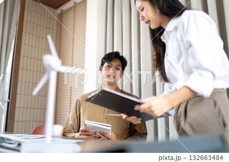 Sustainable Collaboration. Professionals discussing renewable energy solutions in a modern office. 132663484