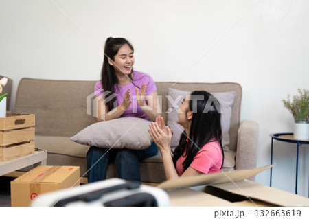 Clapping joyfully A lesbian couple celebrating their new home 132663619