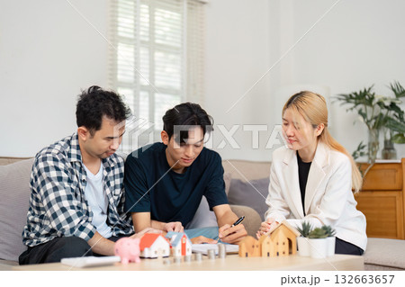 Couple planning real estate investment with a consultant in a modern living room Couple planning real estate investment with a consultant in a modern living room 132663657