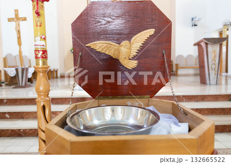 A beautifully designed Baptismal Font featuring a Dove Symbol within the Church setting A beautifully designed Baptismal Font featuring a Dove Symbol within the Church setting 132665522