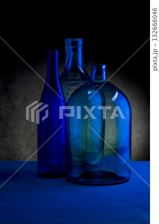 Still life with three glass bottles on a dark background Still life with three glass bottles on a dark background 132666046