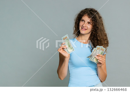 Woman counting cash dollars money happily satisfied celebrating salary savings financial earnings Woman counting cash dollars money happily satisfied celebrating salary savings financial earnings 132666468