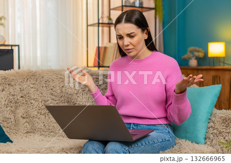 Young woman sitting on sofa having video call receiving bad news feeling sad disappointed emotional Young woman sitting on sofa having video call receiving bad news feeling sad disappointed emotional 132666965