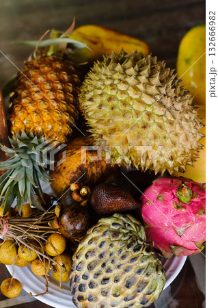 Vibrant assortment of exotic fruits displayed on a white plate in a tropical setting with vivid colors and textures at midday 132666982