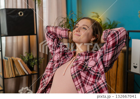 Business woman freelancer taking break leaning on chair relaxing after working Business woman freelancer taking break leaning on chair relaxing after working 132667041