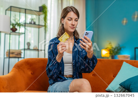 Happy young woman doing payments online purchase shopping in internet store holding bank credit card Happy young woman doing payments online purchase shopping in internet store holding bank credit card 132667045