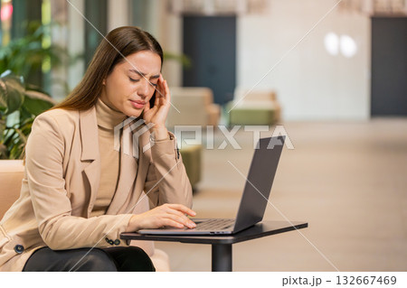 Tired businesswoman freelancer use laptop suffering from headache problem tension migraine stress Tired businesswoman freelancer use laptop suffering from headache problem tension migraine stress 132667469