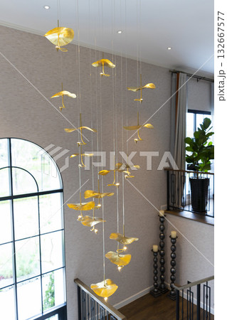 Home entrance hallway with modern chandelier and stairway  132667577