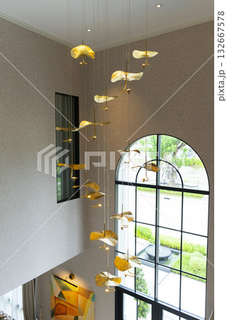 Home entrance hallway with modern chandelier and stairway  132667578