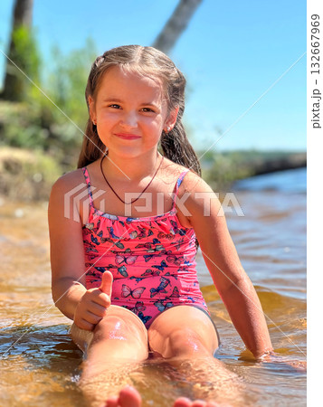 A Joyful Girl Having Fun While Playing in Water on a Bright Sunny Day A Joyful Girl Having Fun While Playing in Water on a Bright Sunny Day 132667969