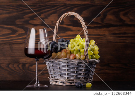Red wine glass and basket of fresh grapes 132668344