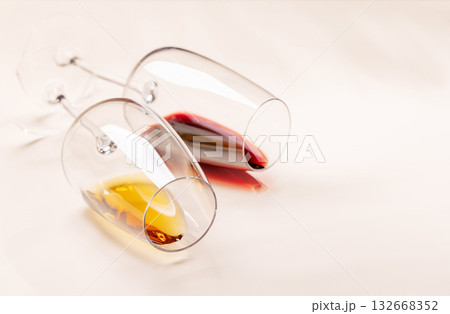 Wine glasses with red and white wine lying on beige background 132668352
