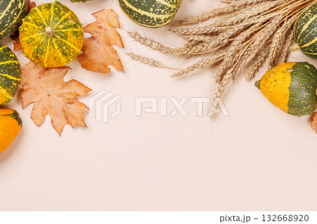 Autumn still life with pumpkins and leaves on beige background 132668920