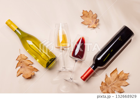 Wine glasses with autumn leaves on beige background 132668929