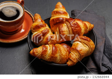 Aromatic croissants in bowl with cup of coffee 132668944