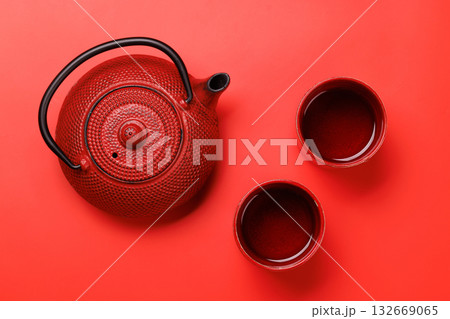 Red teapot on a red background, top view Red teapot on a red background, top view 132669065