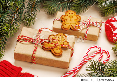 Christmas card with fir branches, gifts and cookies on beige surface 132669093