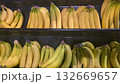 Bunches of bananas in large crates on supermarket shelves, ready for sale. 132669657