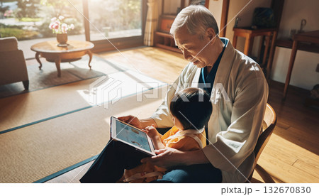 高齢男性が孫と一緒にタブレットを操作する家族の時間 高齢男性が孫と一緒にタブレットを操作する家族の時間 132670830