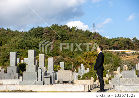 喪服を着て墓地にたたずむ中高年男性 132671328
