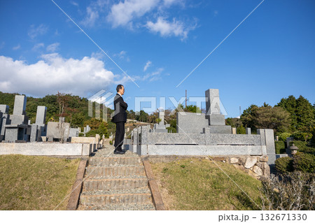 喪服を着て墓地にたたずむ中高年男性 132671330