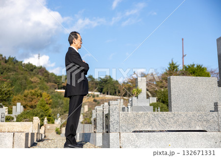 喪服を着て墓地にたたずむ中高年男性 132671331