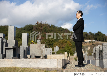 喪服を着て墓地にたたずむ中高年男性 132671332