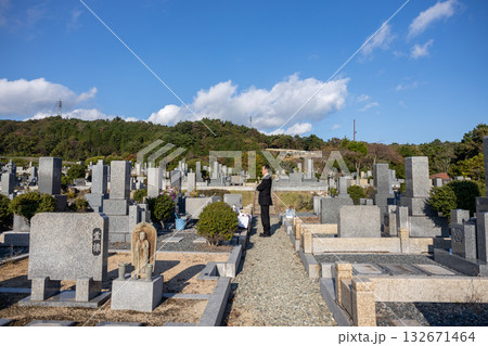 喪服を着て納骨のため墓地にたたずむ中高年男性 132671464