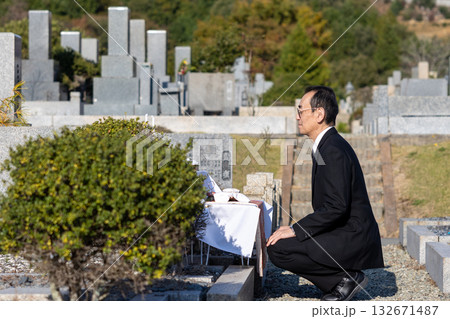 喪服を着て納骨のためお墓にいる中高年男性 喪服を着て納骨のためお墓にいる中高年男性 132671487