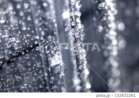 Close up of abstract floating bubbles water droplets condensation rain on a glass transparent bokeh background Close up of abstract floating bubbles water droplets condensation rain on a glass transparent bokeh background 132672261