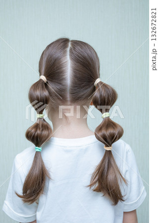Classic, simple and elegant hairstyle with stylish hair accessory, rear view. Little girl back hairstyle view. Macrame flower accessory. Copy space. 132672821