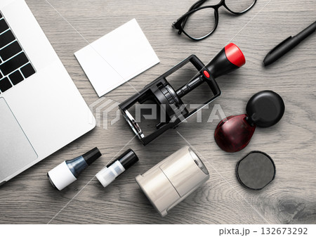 Set of stamps, ink bottles, and laptop on wooden desk Set of stamps, ink bottles, and laptop on wooden desk 132673292