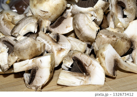 Close up of chopped sliced raw mushrooms on a chopping board prepared for cooking 132673412