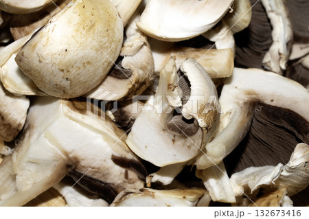 Close up of chopped sliced raw mushrooms on a chopping board prepared for cooking Close up of chopped sliced raw mushrooms on a chopping board prepared for cooking 132673416