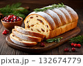 Christmas bread sprinkled with icing sugar and decorated with rosemary lying on wooden board 132674779
