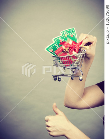 Woman hand holding cart with christmas tree Woman hand holding cart with christmas tree 132675699