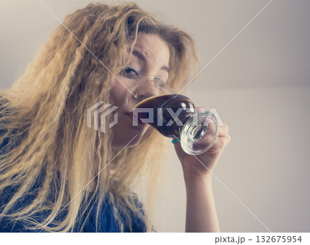 Positive woman drinking her morning coffee 132675954