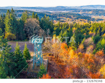 Slovanka Lookout Tower stands tall in the Jizera Mountains, surrounded by vibrant autumn foliage. Visitors enjoy panoramic views of the colorful landscape in fall. Slovanka Lookout Tower stands tall in the Jizera Mountains, surrounded by vibrant autumn foliage. Visitors enjoy panoramic views of the colorful landscape in fall. 132676348